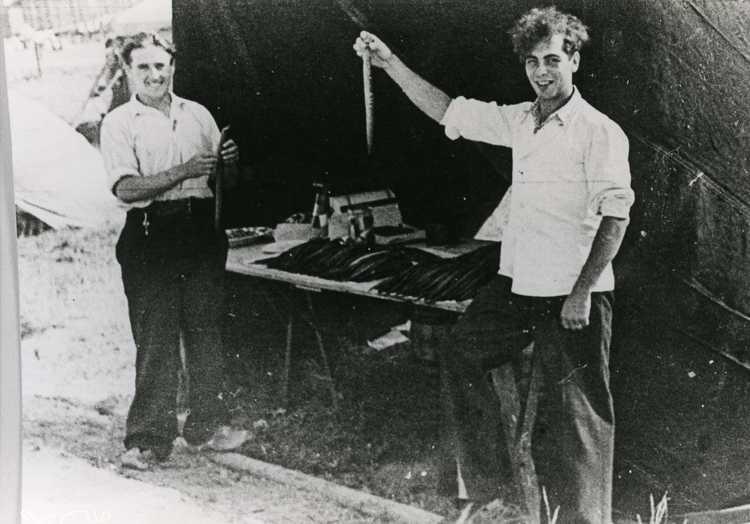 Begin van vishandel Baarssen. Gerrit Baarssen (links) en Rikus Idzerda bij het stalletje aan de Klifweg; collectie museum Het Oude Raadhuis te Urk.