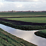 Aansluiting van een sloot op een tocht met de opgeschoonde vegetatie op de kant